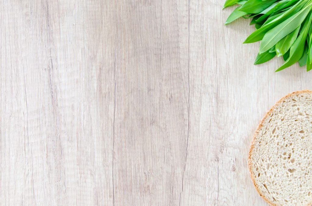 Mastering the First Impression: Your intriguing post title goes here Slice of bread and green leaves on a wooden surface. Perfect for food and health-related content.